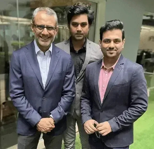 The icon shows company leaders Mr. Amit Dhawan, Mr. Sandeep Singh, and Mr. Shashank Tewari in business formal, all exuding a friendly and approachable demeanor